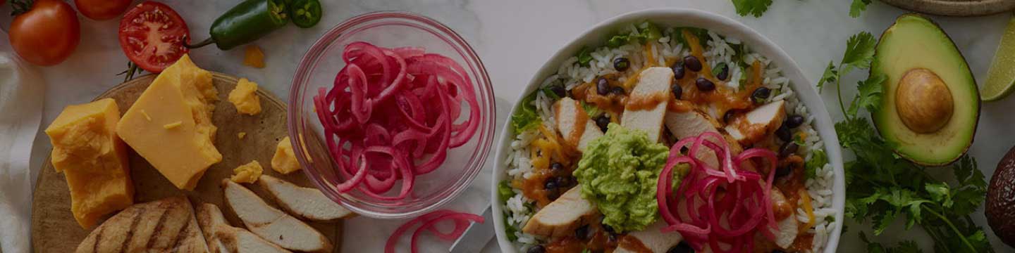 Accessibility banner featuring an aerial shot of Tropical Smoothie Cafe food items - a salad bowl, red onions in a bowl, a sliced avocado and cheese.